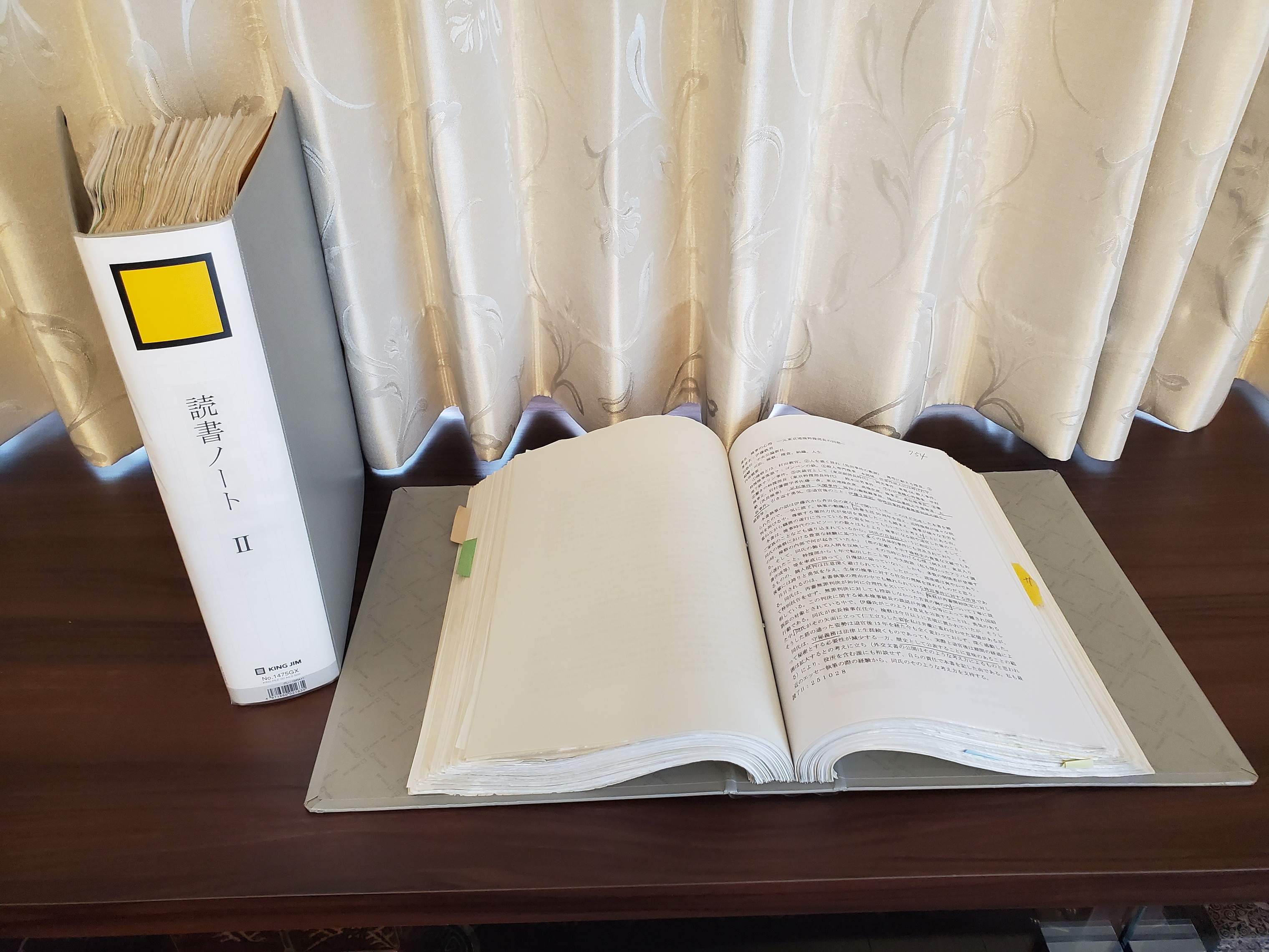 灰色の表紙のパイプファイル2冊が机の上に置かれている